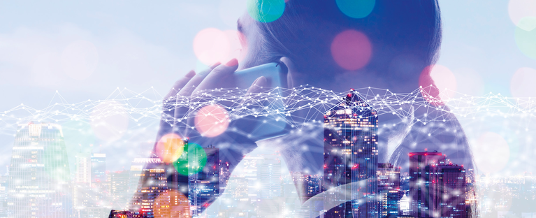 Double exposure of a woman on the phone with a city skyline and global network graphic