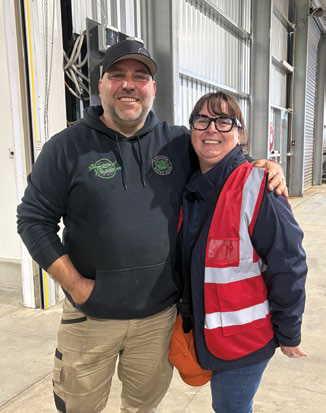 Two men posing at a farm packing facility