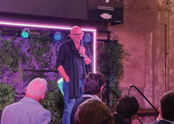 Matt Moran speaking on stage with pink lighting at the Adelaide Casino function