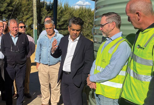 Delegation members talking with growers near water tanks