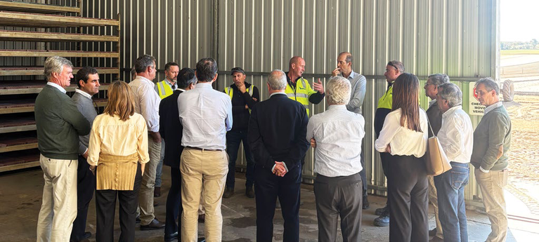 Delegation group listening to a grower inside a farm shed