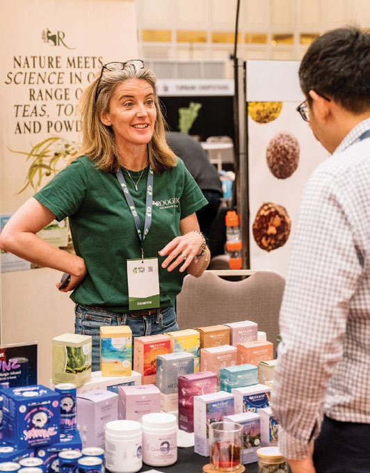 Exhibitor talking with a visitor about tea and natural products
