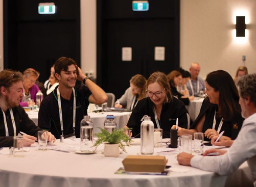 Delegates seated at a round table during a workshop session