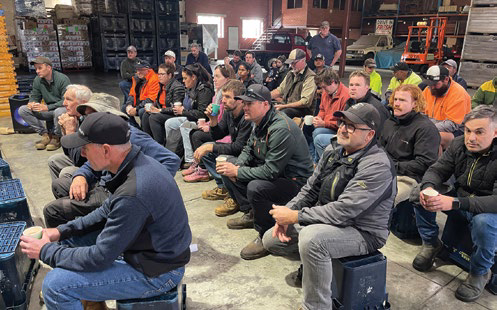 A large group of growers seated listening to a presentation at the orchard walk