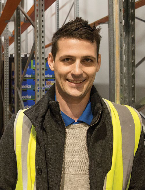 Man in high-visibility safety vest standing in a warehouse
