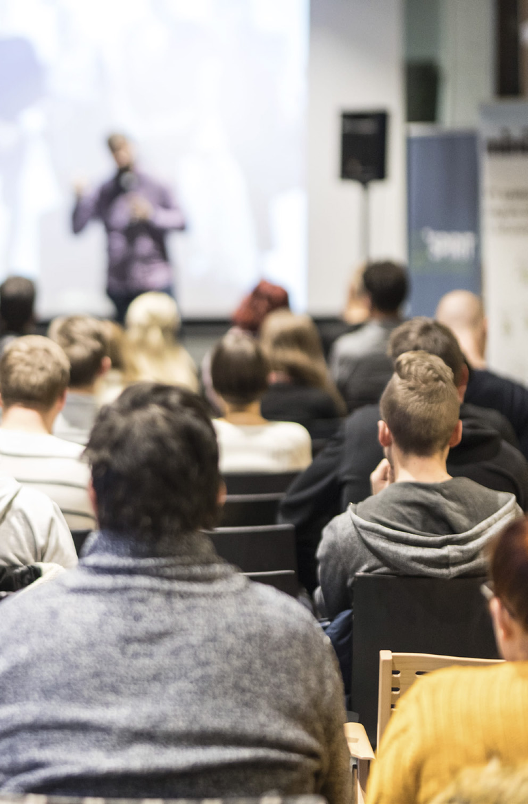 Presenter on stage at a small corporate event